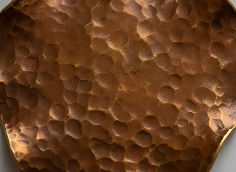 Close-up of hammered brass with irregular texture